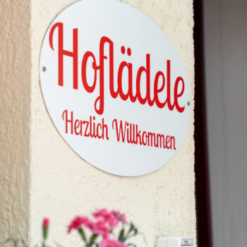 Schild vom Hofladen an Ladenwand